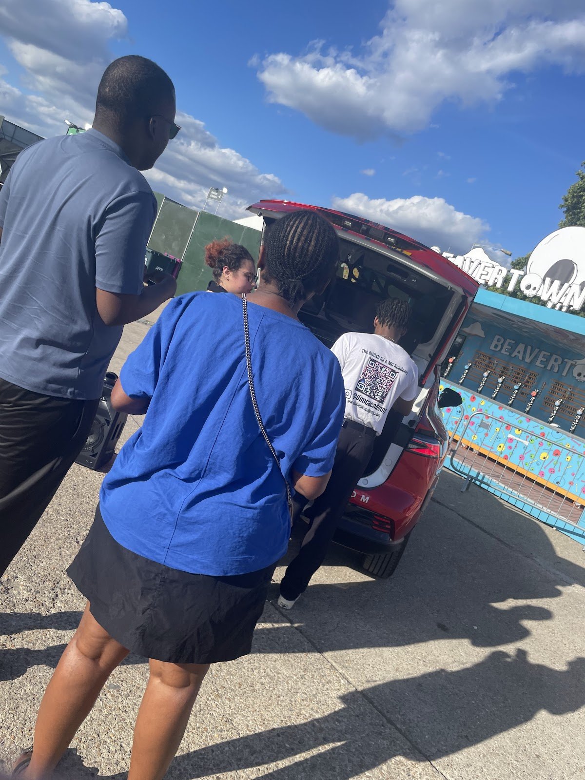 Guests chatting by the DJ car at a sunny Beavertown activation