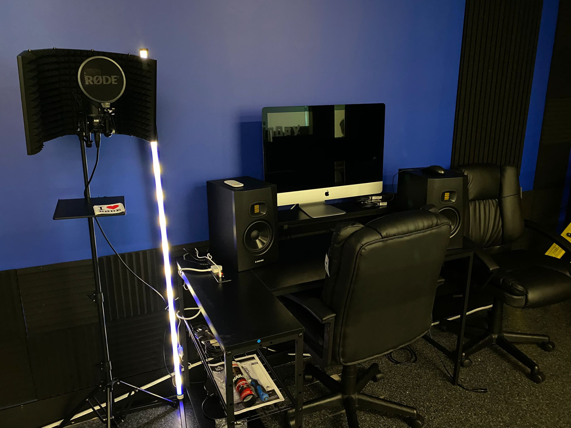 Recording booth with RØDE microphone, iMac and studio monitors