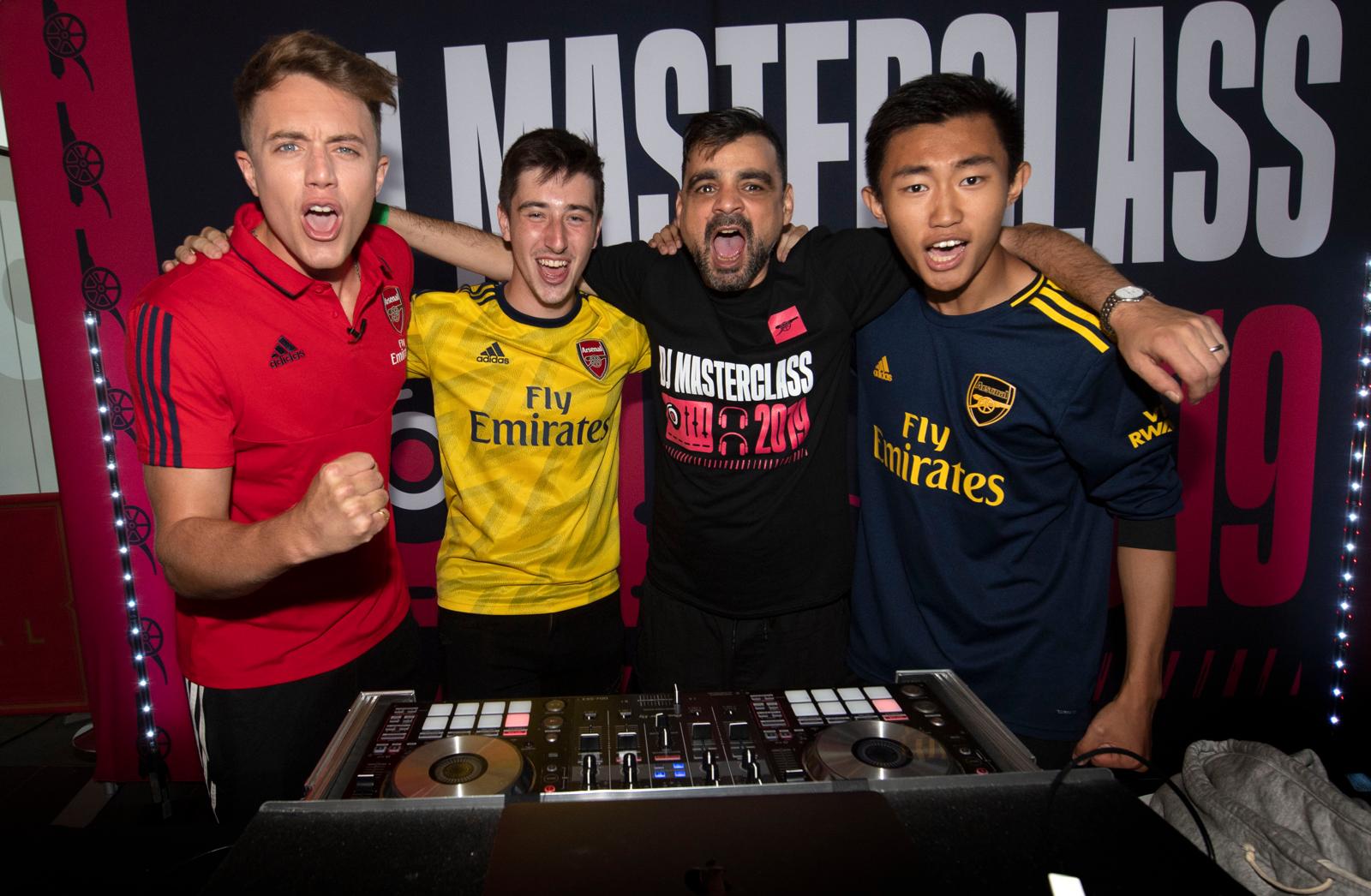 Participants celebrating behind the decks at the Arsenal DJ Masterclass